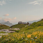 © Le refuge du Fond des Fours vue de loin avec les fleurs en été - Yann Allegre